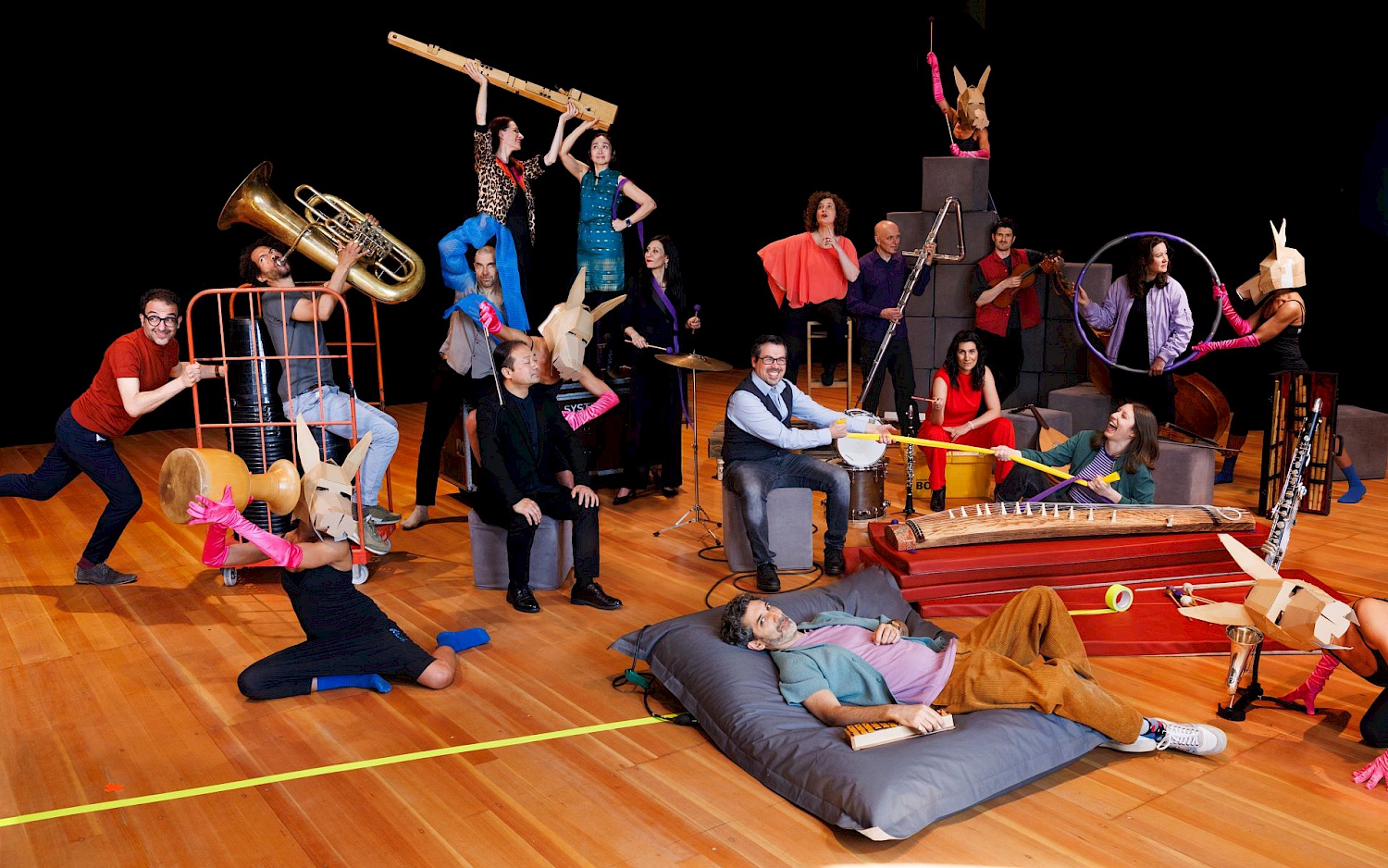 Silke Weinsheimer Gruppenfoto des Trickster Orchestra in bunter Kleidung mit diversen Instrumenten.