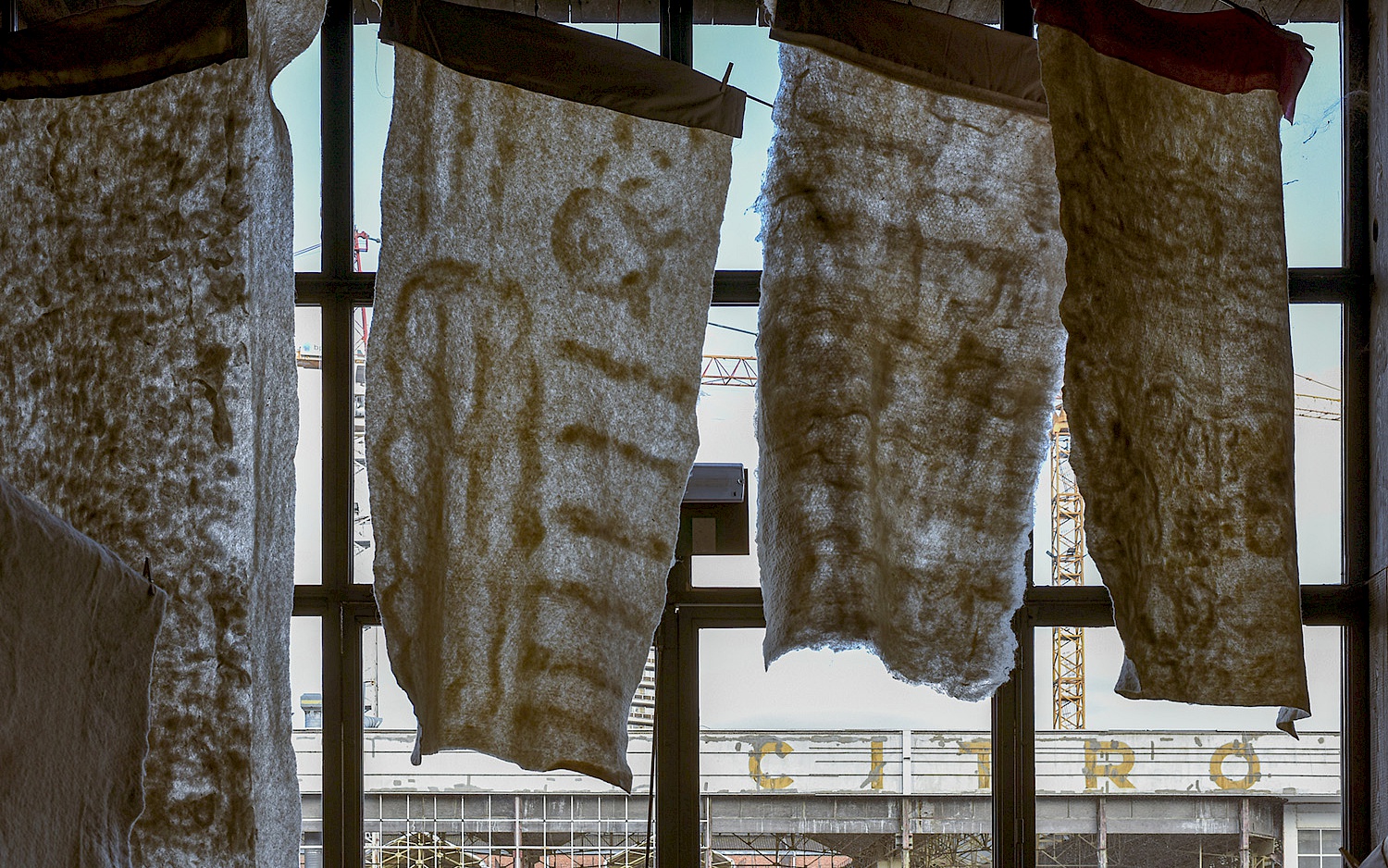 Vier Filzdecken hängen vor einem Fenster als Teil der Performance "Nocturnes for a Society"