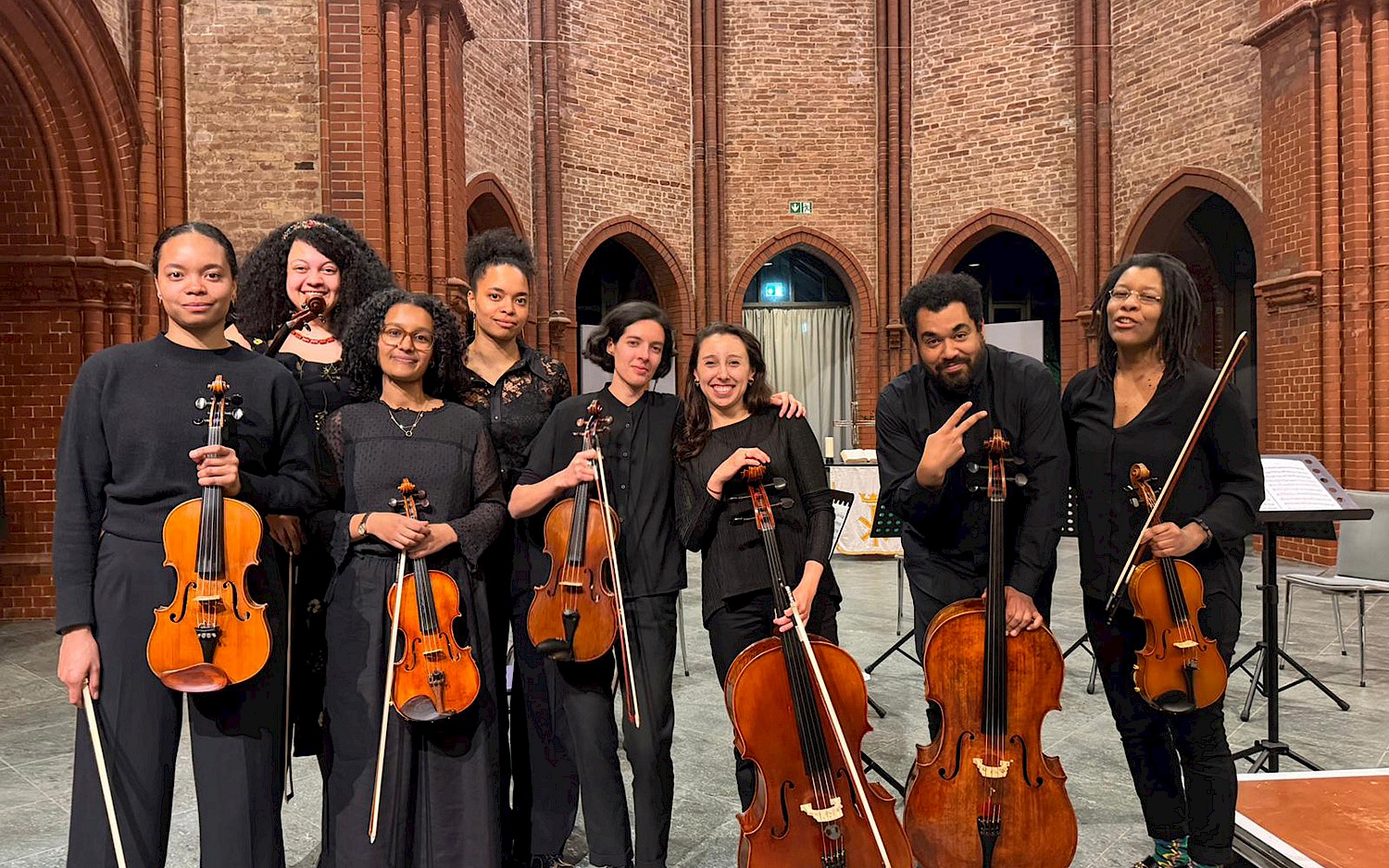 The String Archestra stand together with their instruments as a group